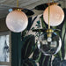 Modern Umbra Colored Glass Pendant lights with artistic orbs in clear and pink hues, enhancing a stylish decor.