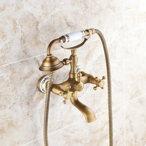 Antique brass handheld shower mixer set with porcelain accents and vintage wall-mounted design in bathroom setting.