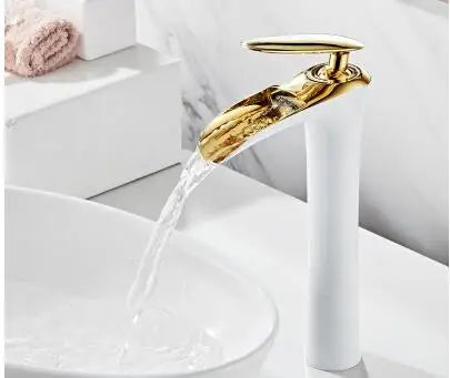 Elegant waterfall basin mixer faucet in white and gold with flowing water in modern bathroom setting