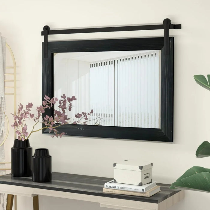 Rustic barn door mirror with solid wood frame and metal bracket, enhancing light and space in a cozy, farmhouse-inspired room.