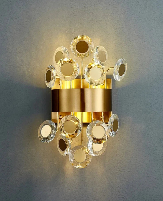 Modern luxury LED crystal wall lamp with decorative gold elements, providing elegant and adjustable lighting on a grey wall.