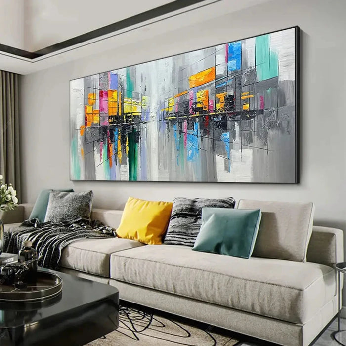 Vibrant cityscape oil painting hangs above a modern living room sofa, showcasing colorful urban life in bold, lively strokes.