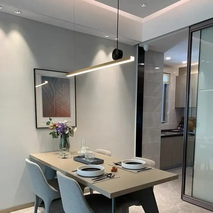 Modern dining area with linear LED bar pendant lamp, minimalist chandelier design, illuminating a contemporary table setting.