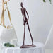 Bronze Giacometti-inspired Walking Man Sculpture on a table, showcasing abstract art with elongated limbs and a textured finish.