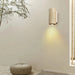 Geometric travertine wall light illuminating a modern room with minimalist decor.