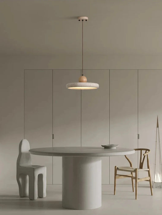 Retro natural stone art pendant in light yellow travertine illuminates a minimalist dining space with modern decor.