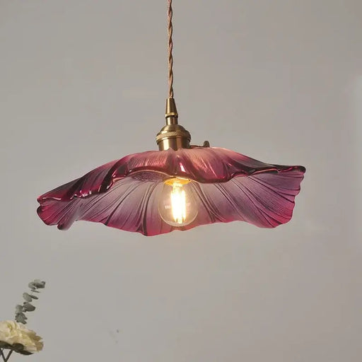 Vintage floral glass pendant light with purple flower design and warm bulb illumination.