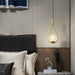 Modern frosted glass globe chandelier hanging beside bed in stylish bedroom with LED light and gold fixture.