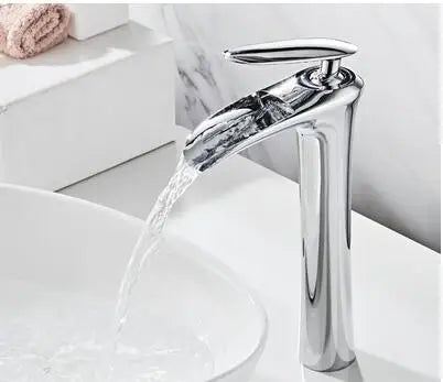 Elegant chrome waterfall basin mixer faucet with water flowing into a white sink, offering modern style and smooth performance.