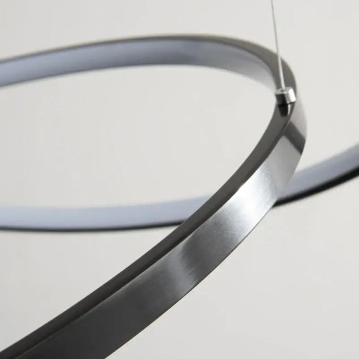 Close-up of modern LED multi-ring chandelier with sleek aluminium design and adjustable ring feature.