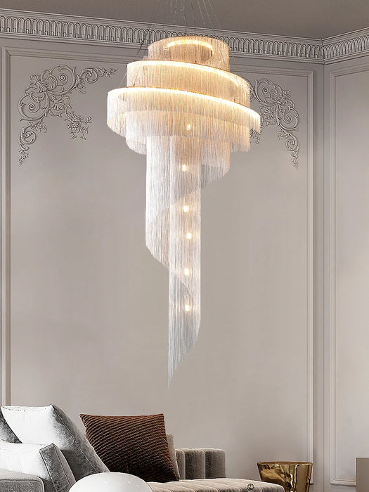 Modern loft spiral chandelier with golden tassels, illuminating a luxurious living room with contemporary elegance.