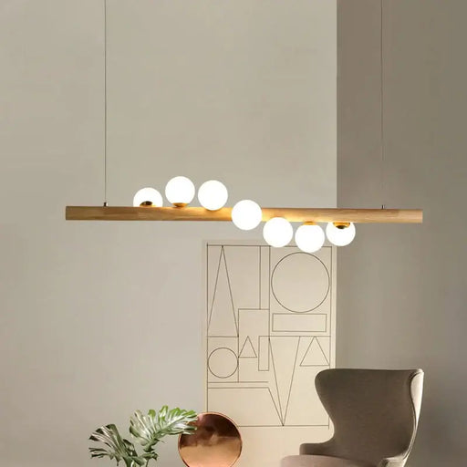 Modern Minimalist Strip Chandelier with wooden beam and hanging orbs in a stylish interior setting.