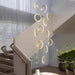 Nordic rings pendant chandelier illuminating modern staircase with Scandinavian elegance and contemporary design.