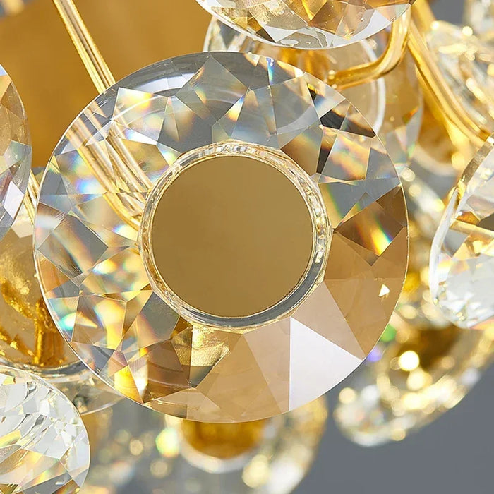 Close-up of crystal design on a modern luxury LED wall lamp with gold accents and reflective surfaces.