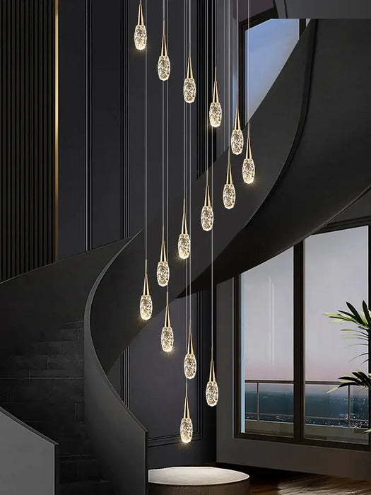 Elegant multi glass-heads LED staircase chandelier illuminating modern space with warm, ambient glow.