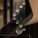 Luxury Crystal Sphere Chandelier in modern interior staircase with elegant lighting and polished stainless-steel finish.