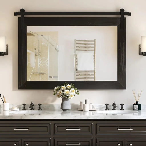 Rustic barn door mirror with solid wood frame and metal bracket in a bathroom, enhancing light and space with clear reflections.