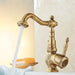 Vintage brass single handle basin faucet with running water, detailed antique design in a bathroom setting.