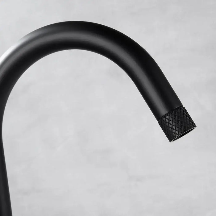 Modern black curved spout of Jade freestanding bathtub faucet with textured detail on nozzle.