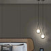 Modern frosted glass globe chandelier with LED bulbs hanging in a stylish bedroom setting.