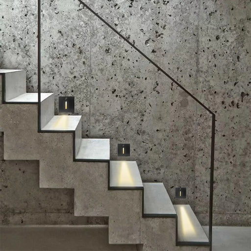 PIR sensor embedded step lights illuminate a modern concrete staircase with smart motion and light sensor technology.