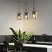 Nordic minimalist glass pendants illuminate a modern kitchen counter with elegant design and efficient LED lighting.