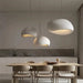 Japanese Wabi-Sabi minimalist pendant chandelier illuminating a modern dining room with wooden table and chairs.