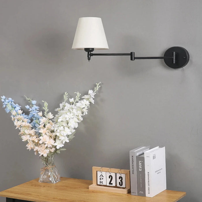 Folding swing arm wall lamp with LED fabric shade in a stylish room setting