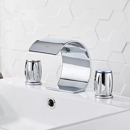 Sleek Wave Shape Waterfall Basin Faucet Set in modern bathroom with hexagonal tile background.