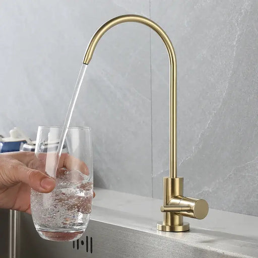 Eco-friendly gold drinking water faucet filling glass in modern kitchen.