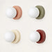 Modern LED wall glass sconces with frosted globes in four colors: pink, green, cream, and maroon, ideal for cozy lighting.