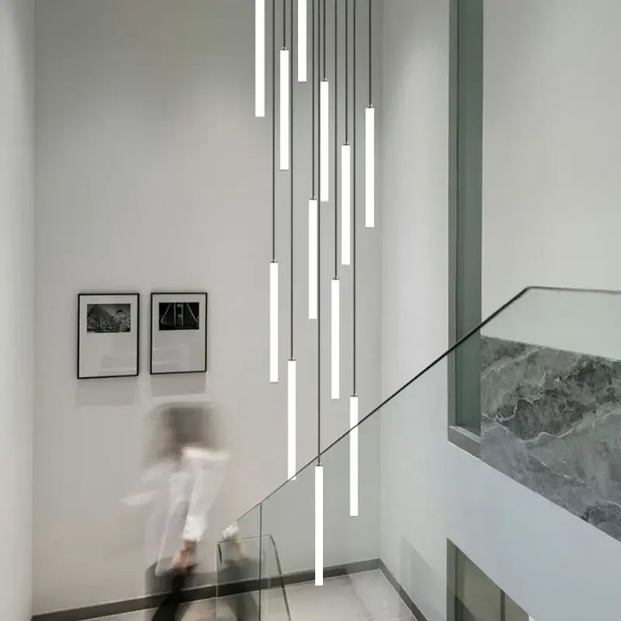 Modern staircase with sleek LED vertical strip chandelier hanging from ceiling.