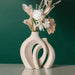 Nordic Boho Ceramic Vase Set with flowers against green background, showcasing modern minimalist design. Ideal for enhancing home decor.