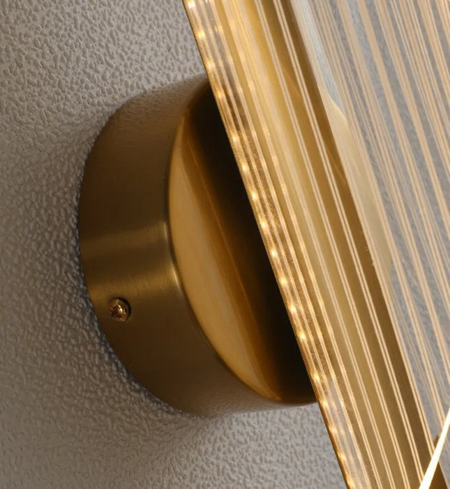 Close-up of Leo Lumis LED Wall Lamp in gold finish with acrylic lampshade, showcasing its modern design and integrated LED lighting.