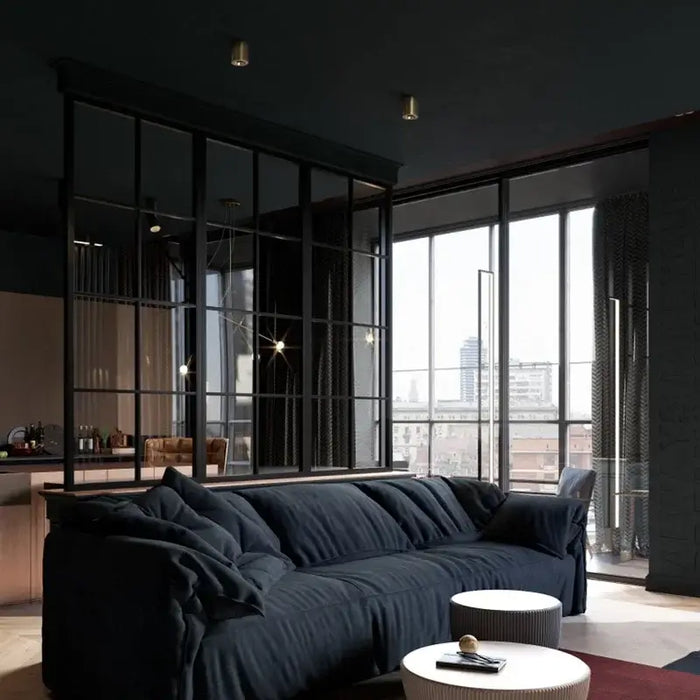 Modern living room with large windows and dark sofa, featuring ceiling-mounted anti-glare LED downlights for elegant illumination.