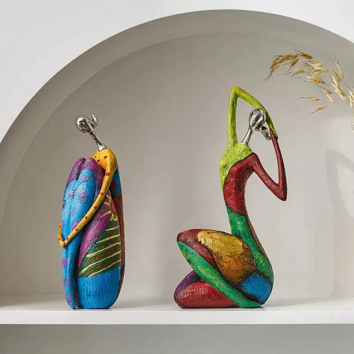 Vibrant Nordic abstract art figurines with colorful patterns and fluid forms on a white shelf, perfect for contemporary decor.