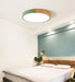 Modern round wooden LED ceiling light illuminating a bedroom with contemporary design and frosted finish.