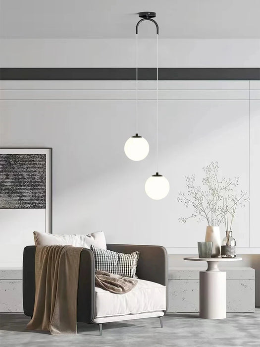 Modern round glass pendant light in minimalist living room with elegant decor.