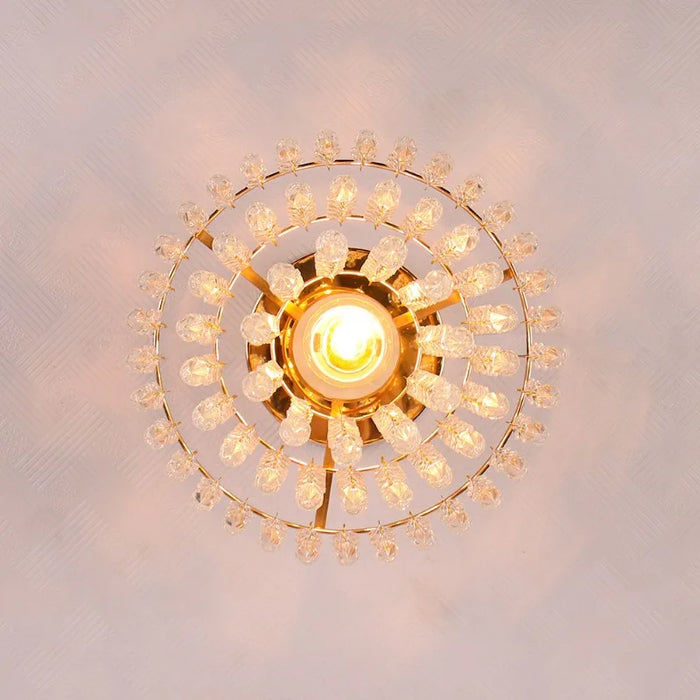 Three-tier crystal ceiling chandelier with LED bulb and stainless steel frame, viewed from below, illuminating a large area.