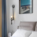 Retro glass wall lamp illuminating a modern bedroom with a minimalistic aesthetic.