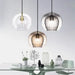 Modern glass double shade pendant lights hanging over a stylish dining table setup.