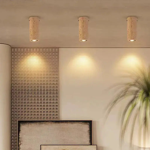 Natural stone cylinder ceiling lights illuminating a modern interior space with warm, inviting glow, enhancing the room's ambiance.