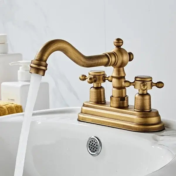 Classic Bronze Dual-Handle Basin Mixer with vintage design and 360° swivel spout, complementing a bathroom sink.