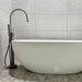 modern freestanding bathtub mixer with shower handle next to white bathtub in contemporary bathroom