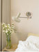 White retractable bedside wall lamp in bedroom with floral decor and modern design.