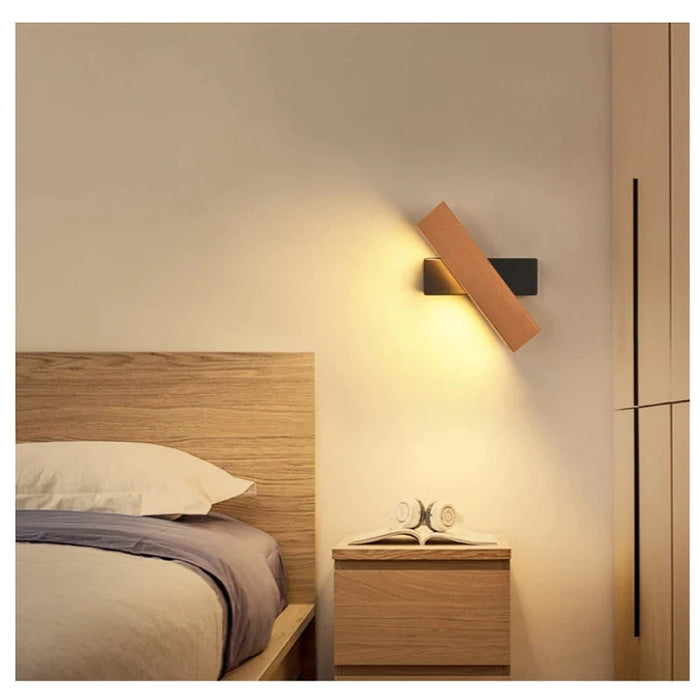 Modern bedroom with 360° rotatable LED wall lamp illuminating a cozy reading nook.