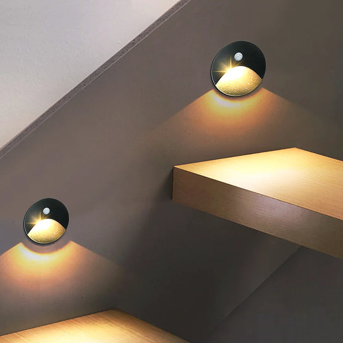 Recessed LED motion sensor wall lamps illuminating a stairway with warm light, offering smart light control and energy efficiency.