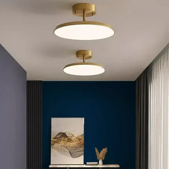 Modern rotatable LED ceiling light in minimalist room design, featuring gold fixtures and a contemporary interior setting.