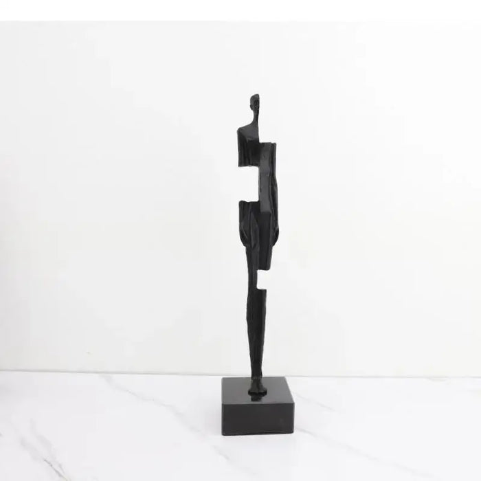 Modern black cast iron sculpture, minimalist abstract design on a marble surface, perfect for contemporary decor.