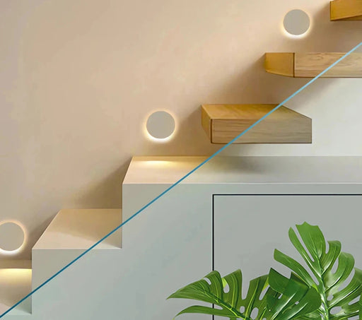 Modern staircase with round recessed waterproof luminaires and green plant adding elegance to indoor decor.